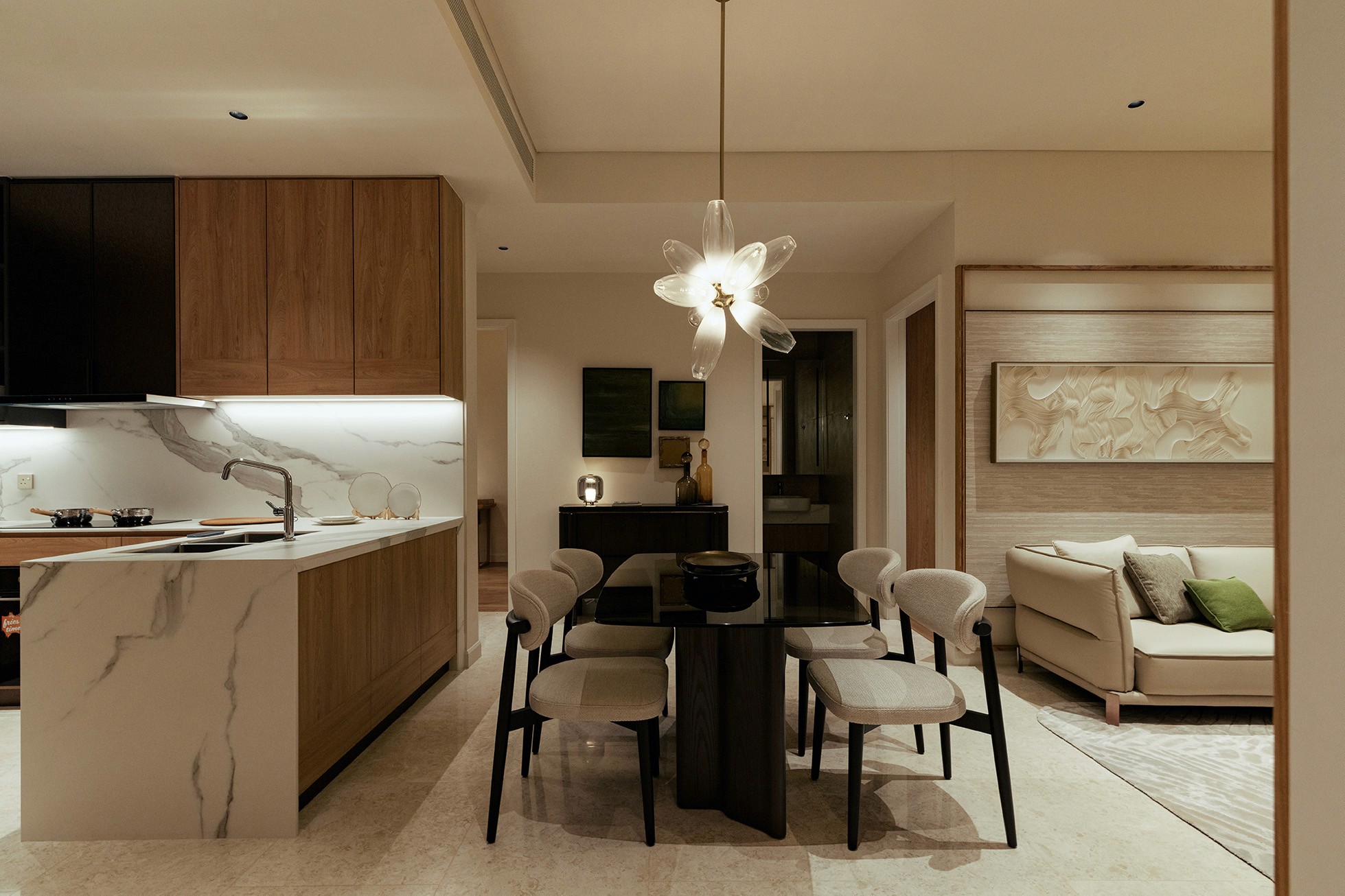 Dining area with sculptural pendant light beside the open kitchen — Gurney Drive Seafront Residences show unit