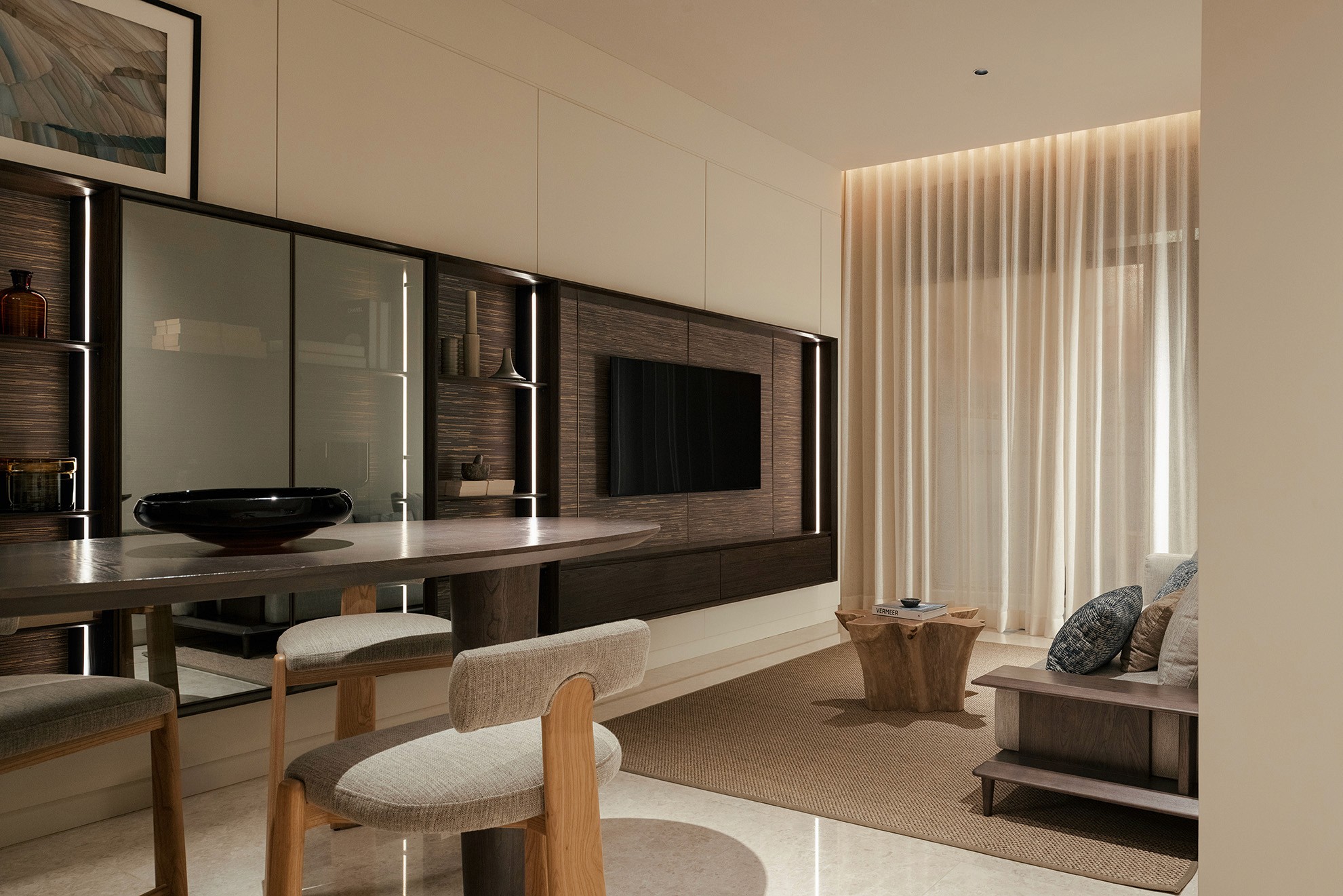 Living area with feature media wall and sheer-draped seafront windows — Gurney Drive Seafront Residences show unit